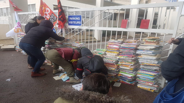 Bloquegen, amb manuals escolars antics, l'entrada a la seu de l'Educació Nacional a Perpinyà